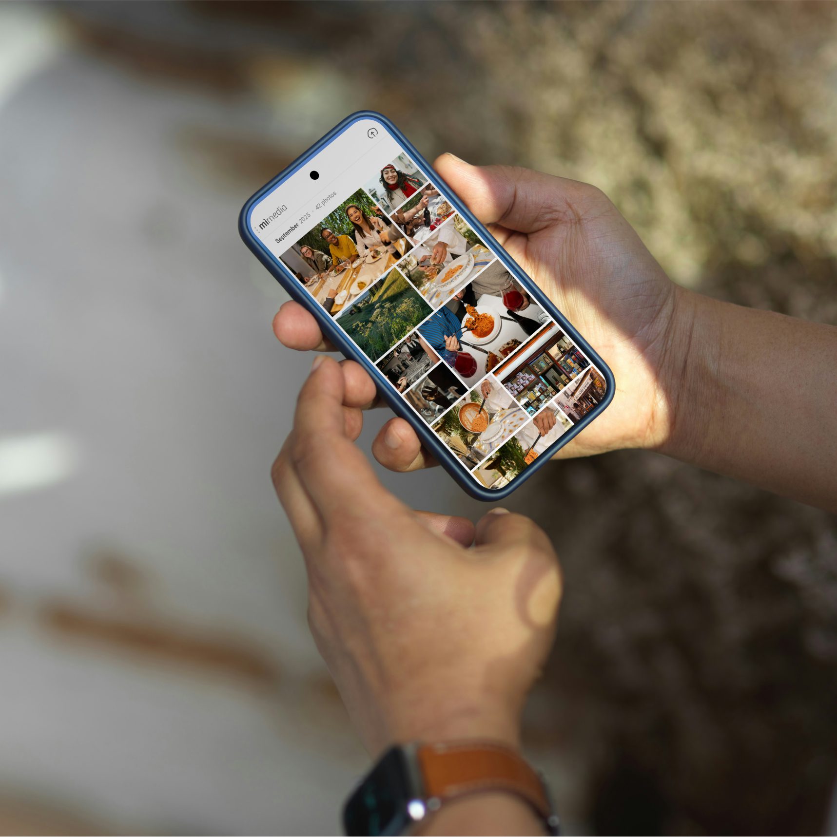 Person holding a smartphone displaying a photo gallery with images of people dining, food, and travel scenes.